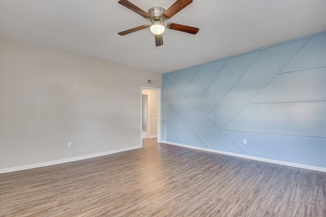 spare room with hardwood / wood-style flooring and ceiling fan