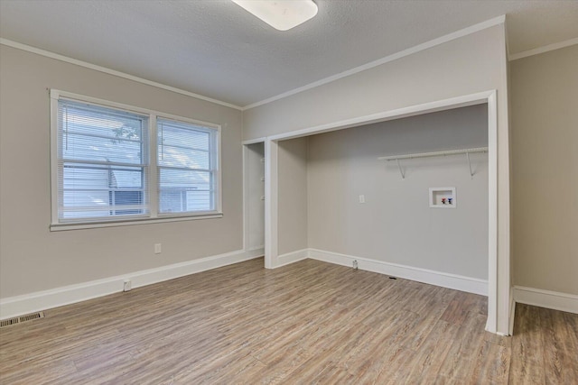 laundry room with crown molding, light hardwood / wood-style flooring, washer hookup, and a textured ceiling