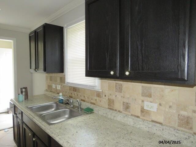 1937 Haynie Dr, Augusta, GA 30904 - kitchen featuring tasteful backsplash, a sink, ornamental molding, light countertops, and dark cabinets