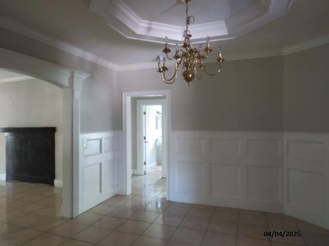 1937 Haynie Dr, Augusta, GA 30904 - unfurnished dining area featuring crown molding, a decorative wall, a fireplace, and tile patterned flooring