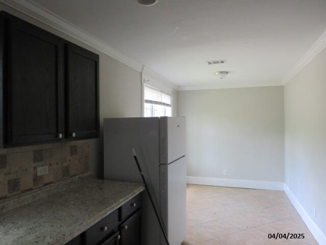 1937 Haynie Dr, Augusta, GA 30904 - kitchen with visible vents, baseboards, freestanding refrigerator, crown molding, and decorative backsplash
