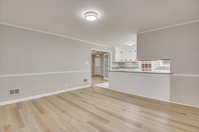 1116 Northwood Rd, Augusta, GA 30909 - unfurnished living room featuring light wood-type flooring, ornamental molding, a wainscoted wall, and ceiling fan