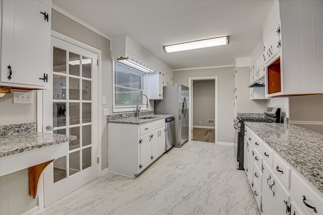 1116 Northwood Rd, Augusta, GA 30909 - kitchen with appliances with stainless steel finishes, under cabinet range hood, crown molding, white cabinets, and light marble finish floors