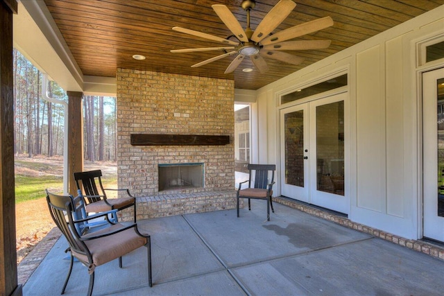 view of patio featuring an outdoor brick fireplace, french doors, and ceiling fan