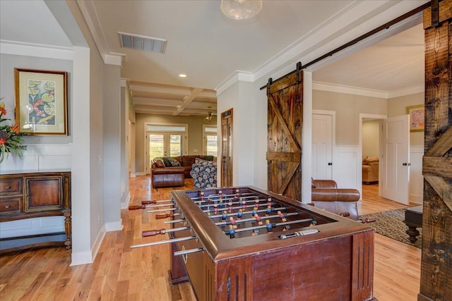 game room featuring ornamental molding, coffered ceiling, beam ceiling, and a barn door