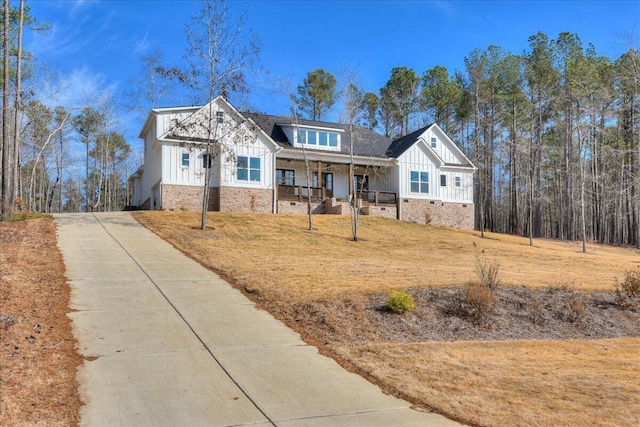 craftsman-style home featuring covered porch and a front lawn