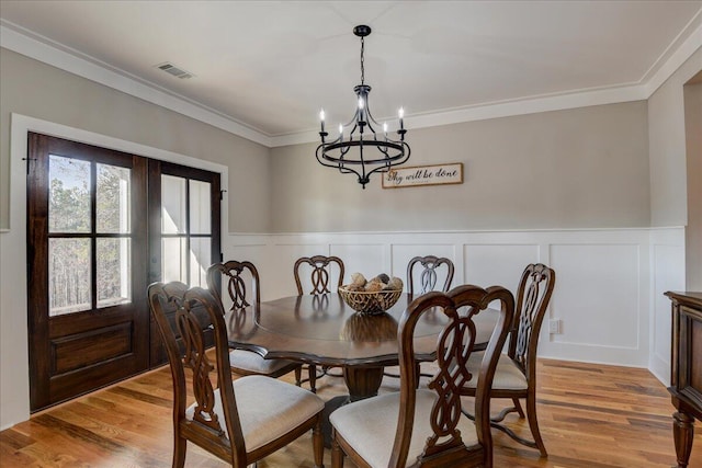 dining area with a chandelier, light hardwood / wood-style flooring, and crown molding