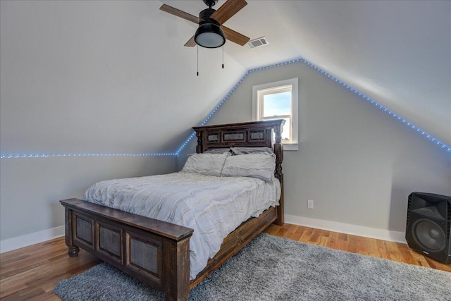 bedroom with ceiling fan, hardwood / wood-style floors, and lofted ceiling