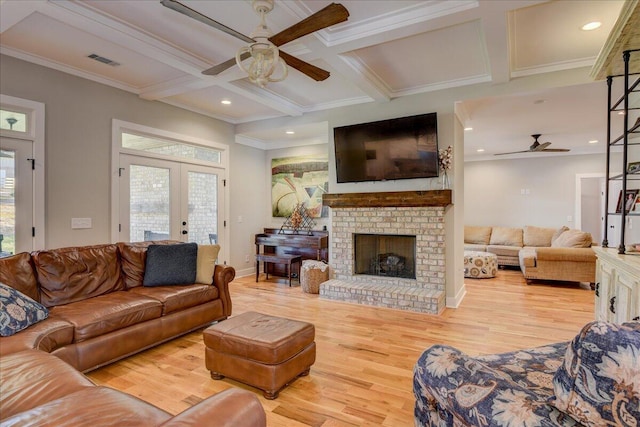 living room featuring light hardwood / wood-style floors, coffered ceiling, french doors, ornamental molding, and beam ceiling