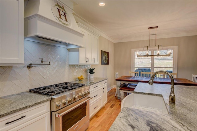 kitchen featuring white cabinetry, light stone countertops, high end stainless steel range, and custom exhaust hood