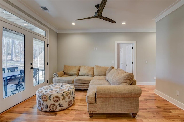 living room featuring light hardwood / wood-style floors, ceiling fan, ornamental molding, and french doors