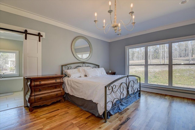 bedroom featuring multiple windows, a barn door, and light wood-type flooring