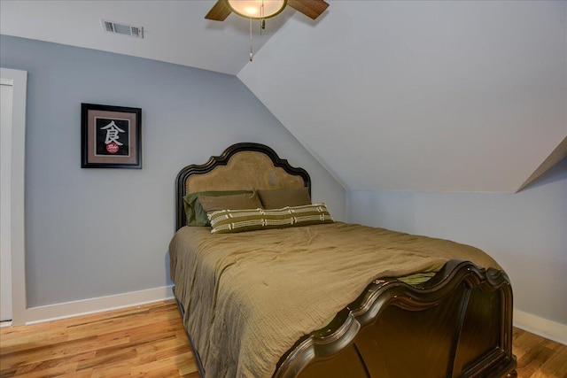 bedroom with ceiling fan, light hardwood / wood-style flooring, and lofted ceiling