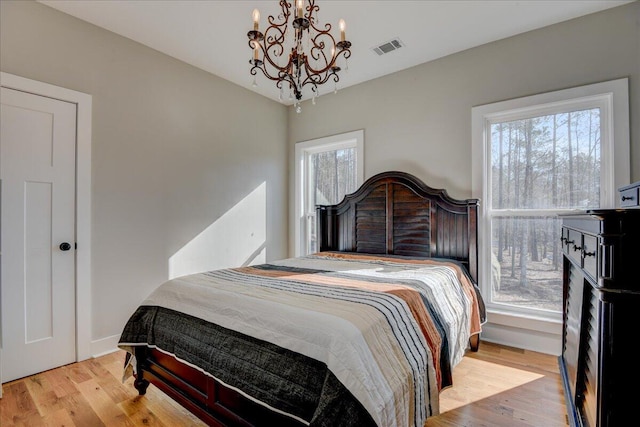 bedroom featuring light hardwood / wood-style flooring and multiple windows