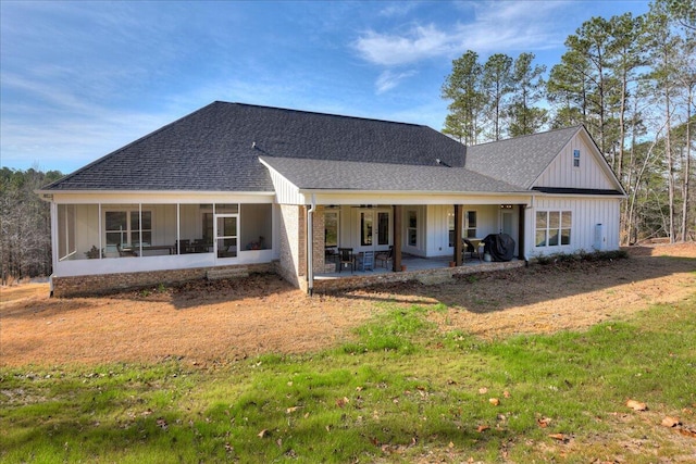 rear view of house with a patio area, a lawn, and a sunroom