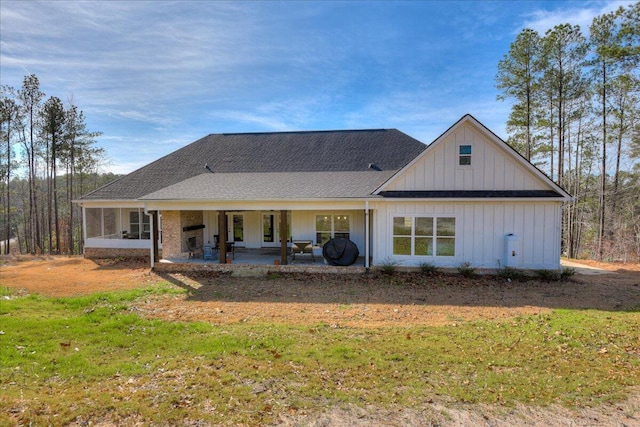 back of house with a lawn and a patio