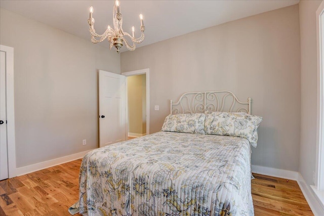 bedroom featuring light wood-type flooring and an inviting chandelier