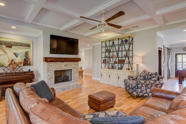 living room with a barn door, ornamental molding, and light hardwood / wood-style floors