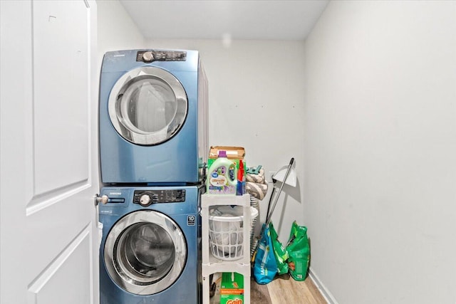 laundry area featuring hardwood / wood-style floors and stacked washer / drying machine