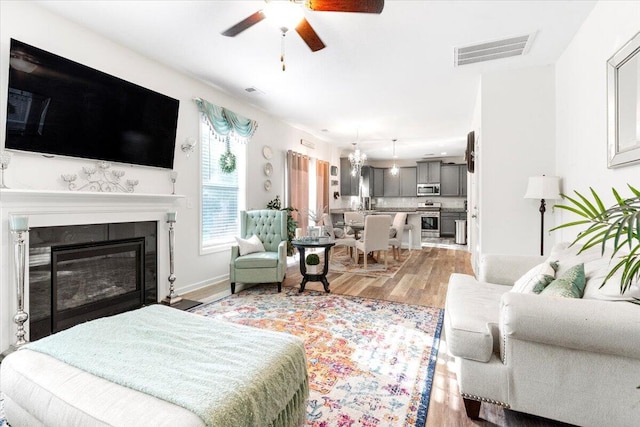 living room with ceiling fan and light hardwood / wood-style floors