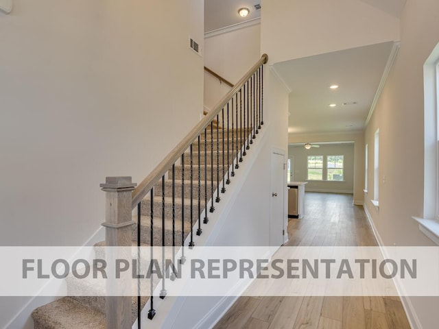 staircase featuring hardwood / wood-style flooring, a towering ceiling, and crown molding