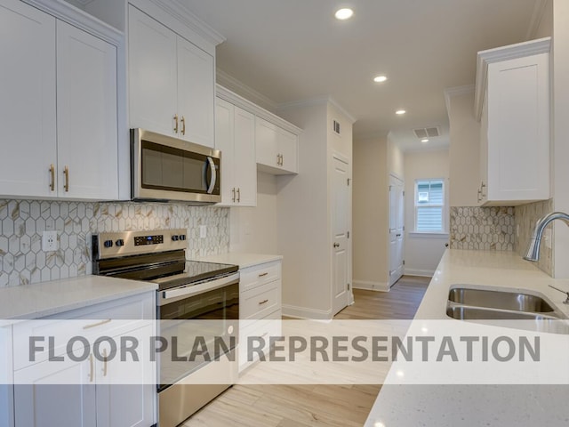 kitchen featuring ornamental molding, appliances with stainless steel finishes, sink, and white cabinets