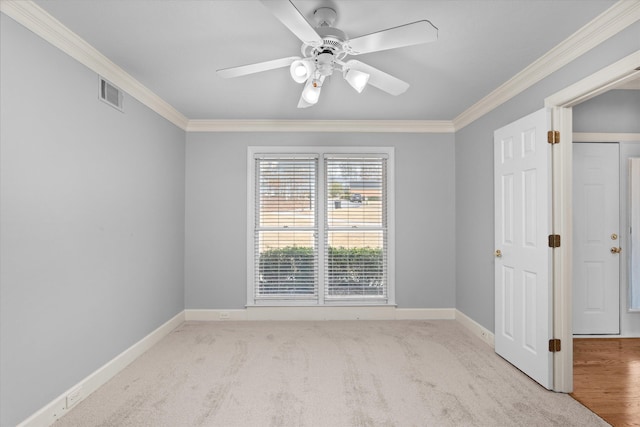 carpeted empty room featuring crown molding and ceiling fan