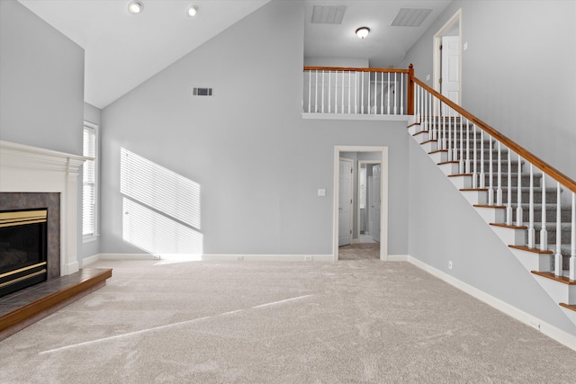 unfurnished living room featuring high vaulted ceiling and carpet floors