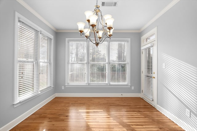 unfurnished dining area featuring an inviting chandelier, hardwood / wood-style floors, and crown molding