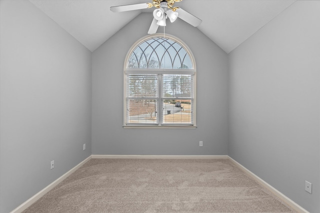 carpeted spare room featuring vaulted ceiling and ceiling fan