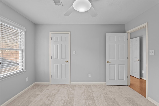 unfurnished bedroom featuring ceiling fan and light colored carpet