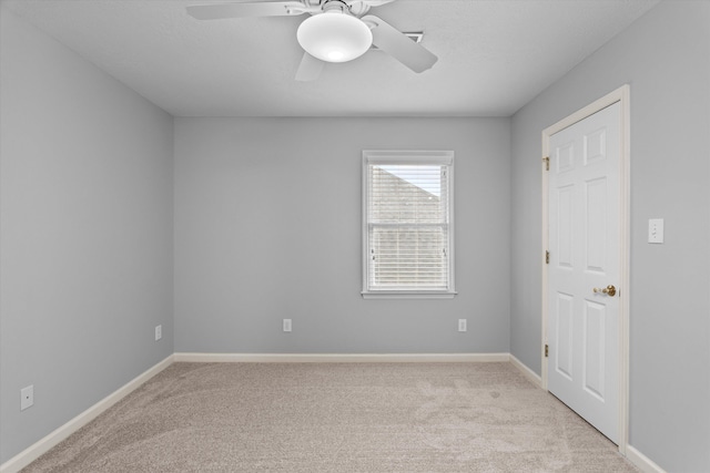 carpeted empty room featuring ceiling fan