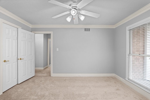 unfurnished bedroom with multiple windows, ornamental molding, and light carpet