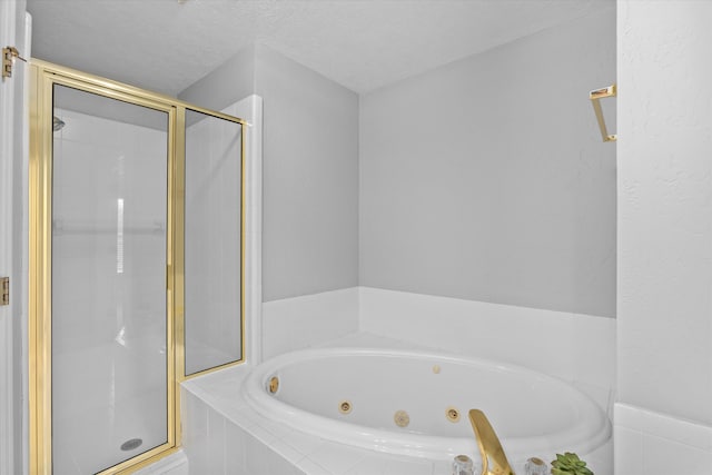 bathroom featuring plus walk in shower and a textured ceiling