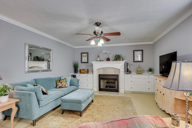 living room with ceiling fan, ornamental molding, a tile fireplace, and light colored carpet