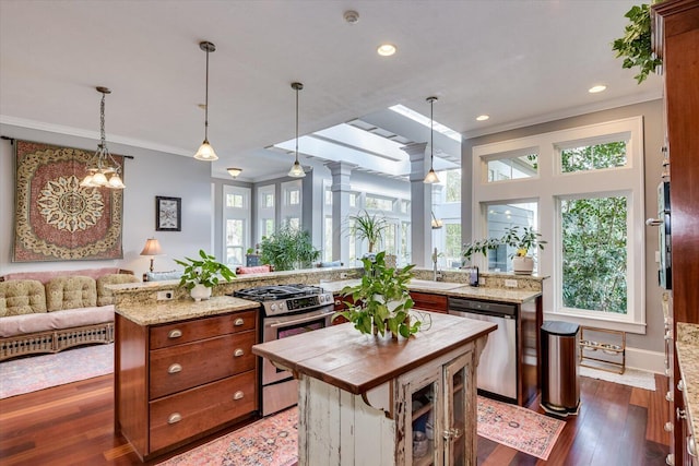 kitchen featuring stainless steel appliances, butcher block countertops, dark wood-style flooring, open floor plan, and ornamental molding