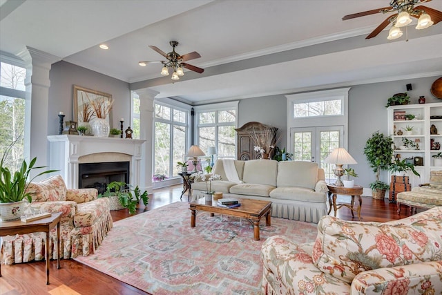 living room with a healthy amount of sunlight, wood finished floors, and crown molding