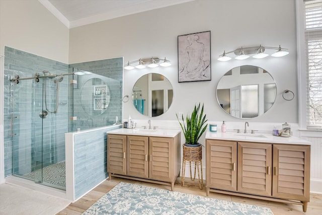 full bath with a stall shower, wood finished floors, vanity, and crown molding