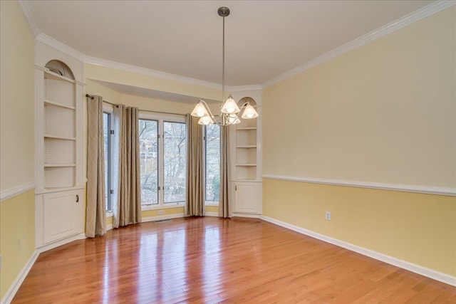 unfurnished dining area with hardwood / wood-style flooring, built in features, and a notable chandelier