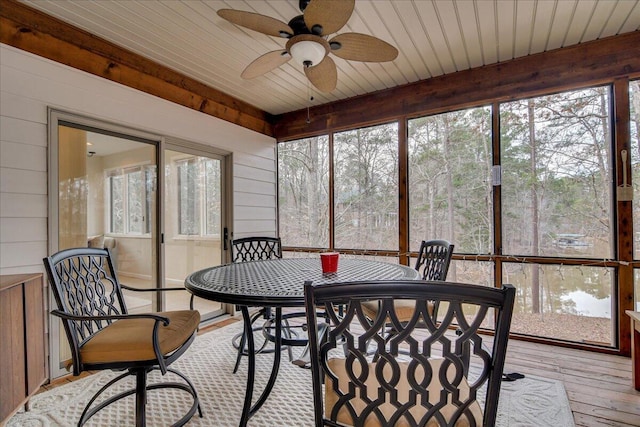 sunroom / solarium with ceiling fan, plenty of natural light, and wood ceiling