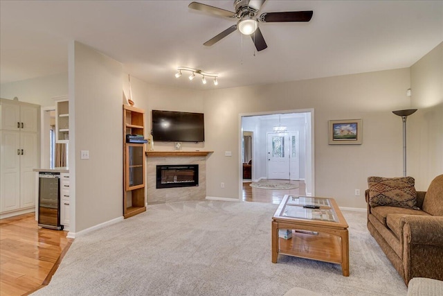 living room with ceiling fan, light colored carpet, and wine cooler