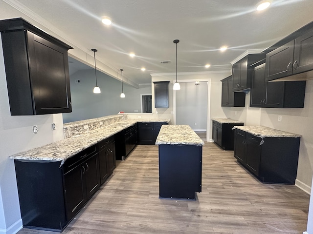 kitchen featuring a center island, light hardwood / wood-style floors, and hanging light fixtures