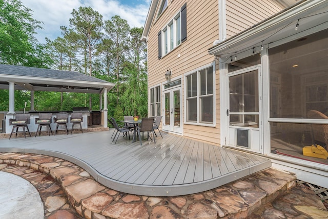 wooden terrace with outdoor dry bar, outdoor dining area, and french doors
