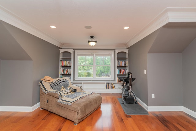 living area featuring wood finished floors, ornamental molding, and baseboards