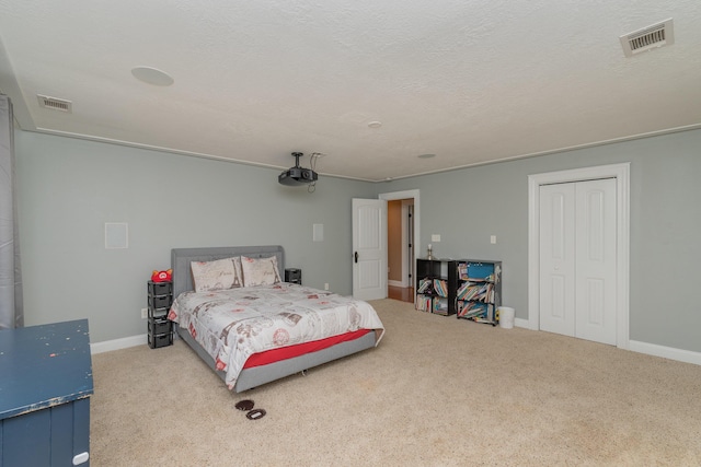 carpeted bedroom featuring visible vents, a closet, and baseboards