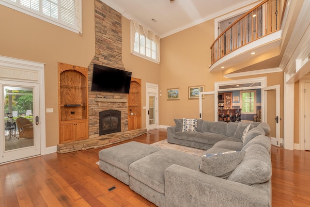 living room featuring ornamental molding, a high ceiling, and a wealth of natural light