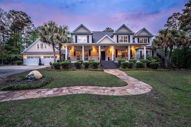 view of front of property with a garage, a yard, covered porch, stairs, and aphalt driveway