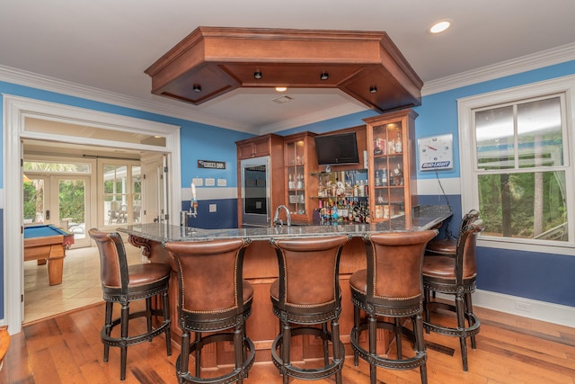 bar with pool table, light wood-style floors, indoor wet bar, a sink, and french doors