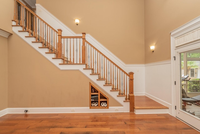 entrance foyer featuring stairway, wood finished floors, and a high ceiling