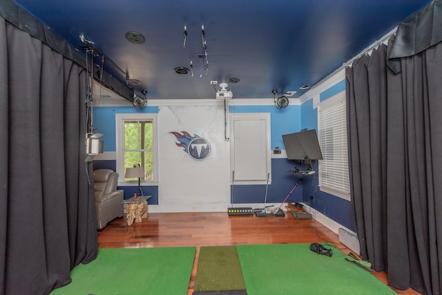 interior space featuring crown molding, wood finished floors, and baseboards
